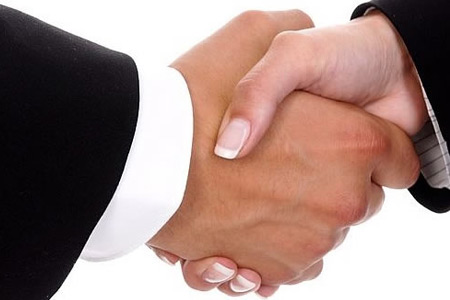 Man and woman in business clothing shake hands.
