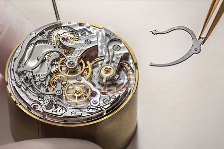 Expert watchmaker assembles watch.